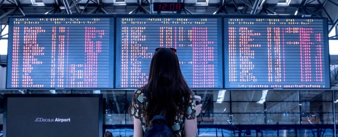 Girl looks at airport arrivals screen